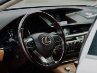 Close-up of a Lexus car interior highlighting the steering wheel in a luxury setting.