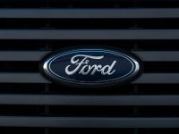 Detailed view of a Ford emblem mounted on a vehicle grille, showcasing modern design.